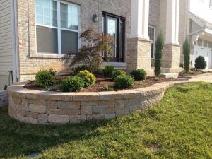 Small front yard landscape design with a retaining wall to accent the garden beds.