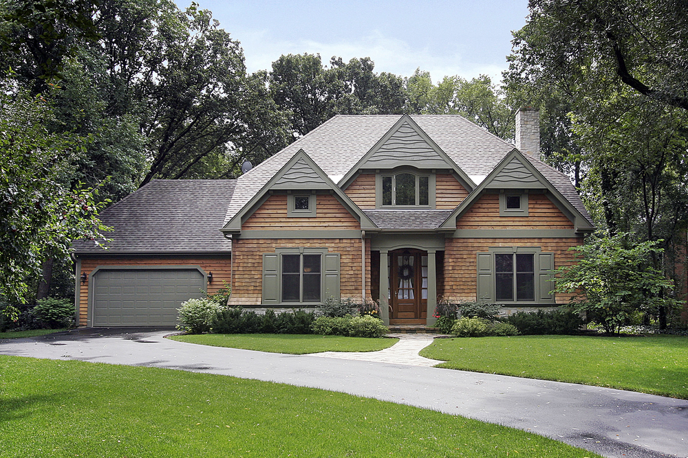 Gorgeous lawn and landscape installed along a paver stone driveway. Well trimmed bushes in a stunning colorful flower bed.